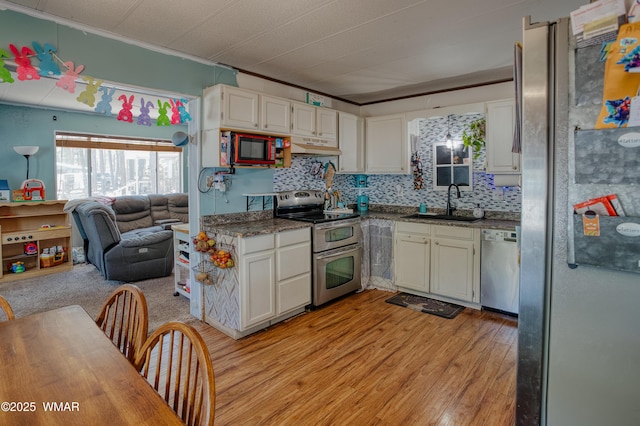 720 S 26th Ave, Show Low, AZ 85901 - kitchen featuring appliances with stainless steel finishes, open floor plan, white cabinetry, light wood-type flooring, and tasteful backsplash