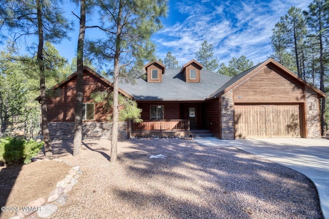 view of front facade with driveway, stone siding, and a garage