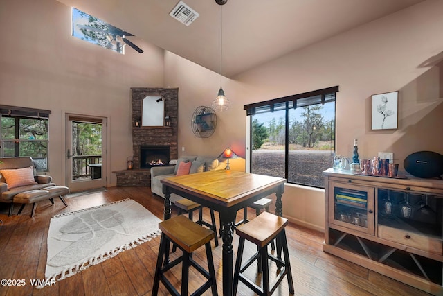 7011 Mercury Dr, Lakeside, AZ 85929 - dining room with hardwood / wood-style floors, a fireplace, a high ceiling, and baseboards
