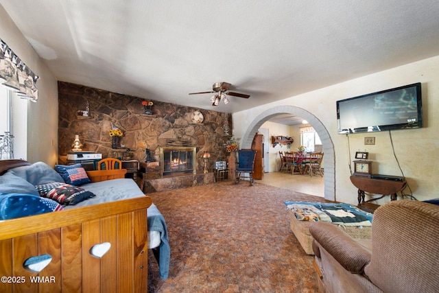 1051 Dusty Ln, Show Low, AZ 85901 - carpeted living area with arched walkways, a ceiling fan, and a fireplace