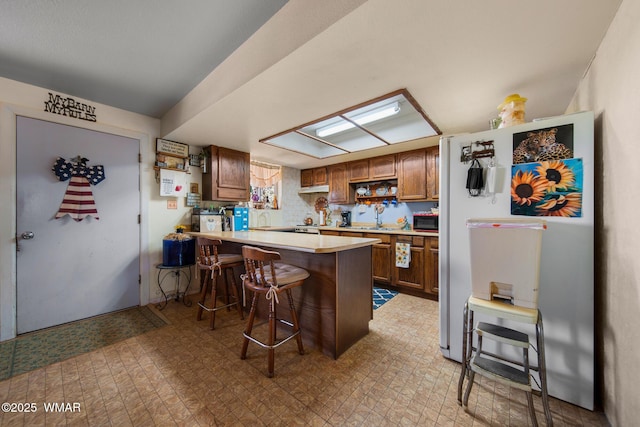 1051 Dusty Ln, Show Low, AZ 85901 - kitchen with a peninsula, white appliances, a breakfast bar area, light countertops, and a sink