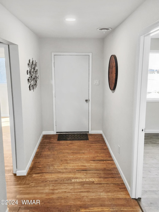 entryway with visible vents, baseboards, and wood finished floors