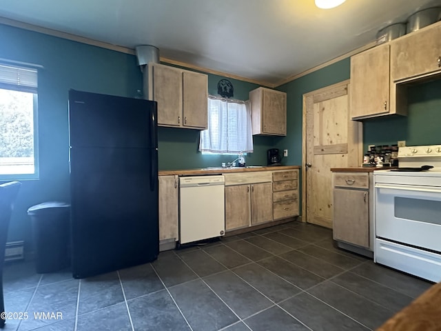 kitchen featuring ornamental molding, white appliances, dark tile patterned floors, and a sink