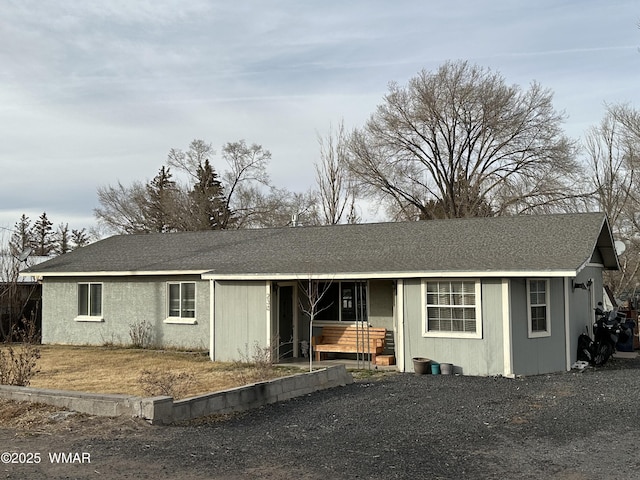 ranch-style home with roof with shingles