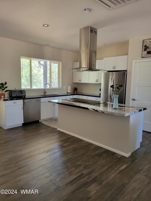 kitchen featuring dark wood finished floors, appliances with stainless steel finishes, white cabinets, a sink, and island range hood