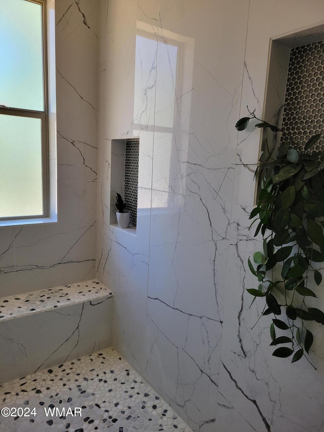 bathroom with a marble finish shower