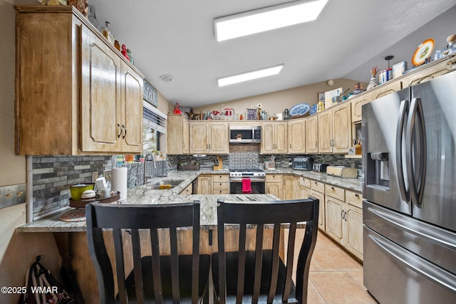 6711 Bandido Way, Show Low, AZ 85901 - kitchen featuring appliances with stainless steel finishes, lofted ceiling, backsplash, a peninsula, and light tile patterned floors