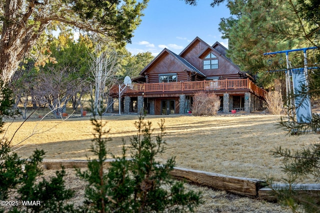 back of property featuring stone siding, stairway, a deck, and log exterior