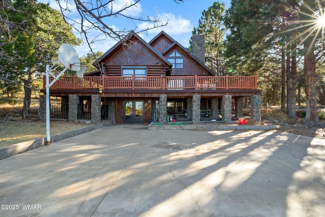 1425 S Amity Ln, Eagar, AZ 85925 - back of house with driveway, stone siding, a chimney, log siding, and a deck