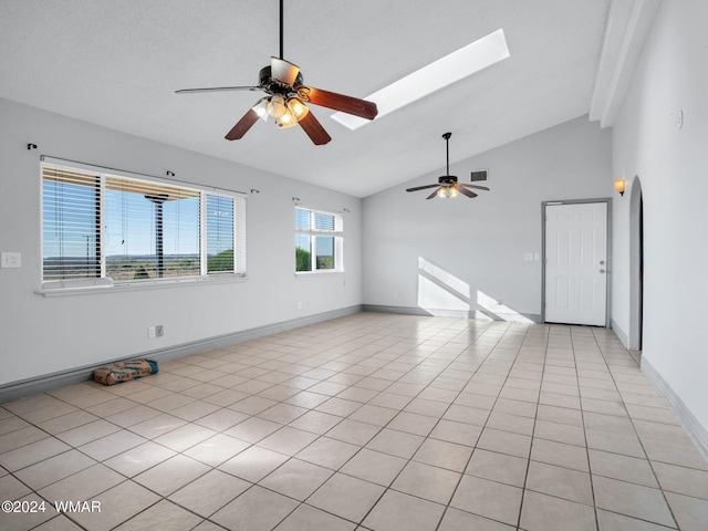 spare room featuring light tile patterned flooring, a skylight, visible vents, and baseboards