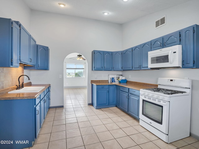 kitchen featuring white appliances, visible vents, a sink, and blue cabinetry