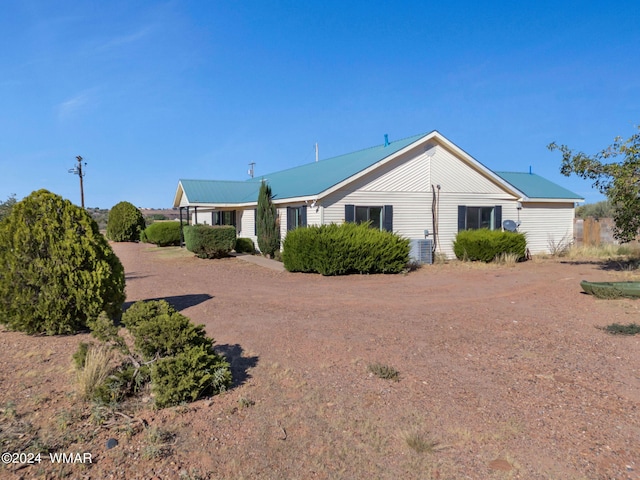 view of front of home with central AC unit and metal roof