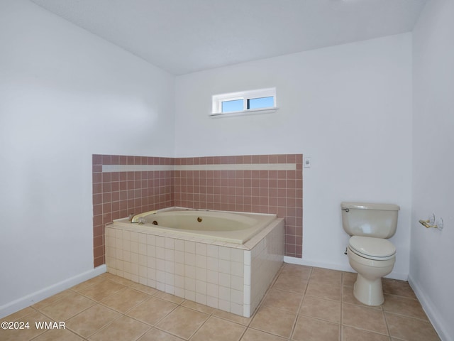 full bath featuring toilet, tile patterned flooring, baseboards, and a bath