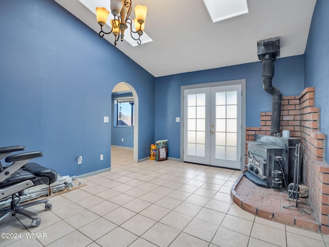 interior space featuring arched walkways, lofted ceiling, light tile patterned flooring, french doors, and a wood stove