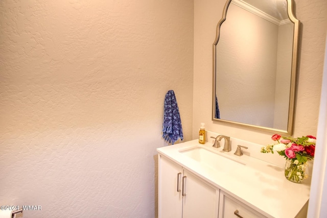 bathroom with a textured wall and vanity