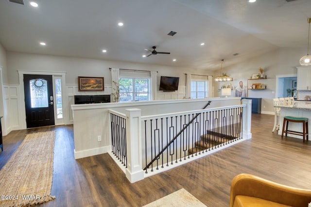 interior space with decorative light fixtures, light countertops, dark wood-type flooring, open floor plan, and vaulted ceiling