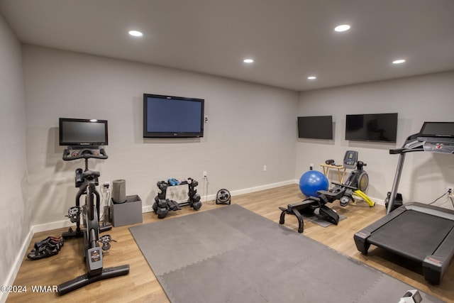 exercise area with baseboards, wood finished floors, and recessed lighting