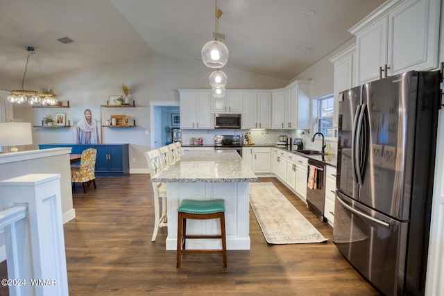 kitchen featuring appliances with stainless steel finishes, a sink, white cabinets, and pendant lighting