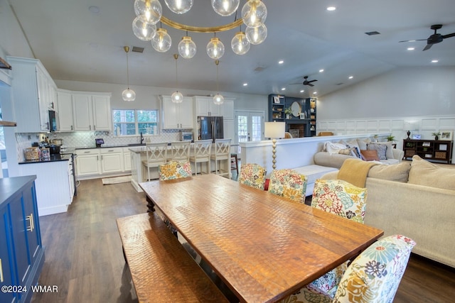 dining area featuring vaulted ceiling, dark wood-type flooring, visible vents, and a ceiling fan