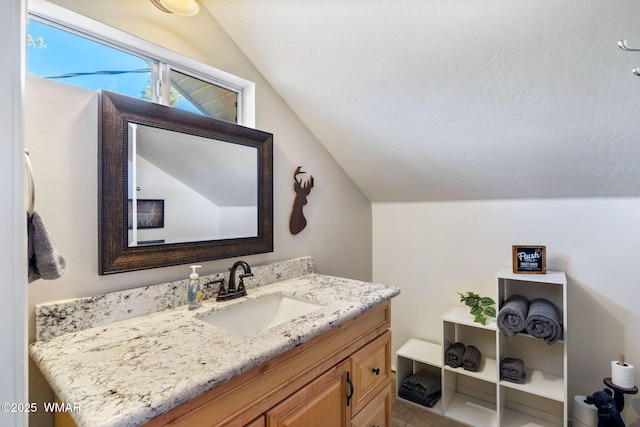 bathroom featuring vaulted ceiling and vanity