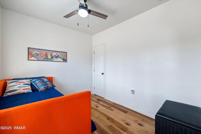 bedroom featuring ceiling fan, baseboards, and wood finished floors