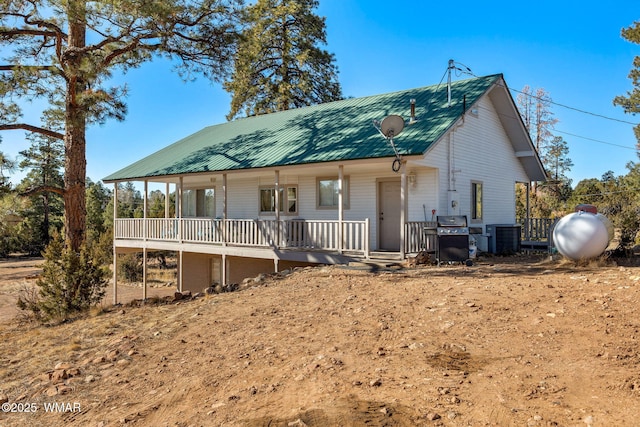 view of front of home featuring metal roof, a porch, and cooling unit