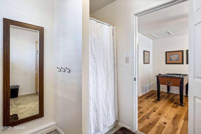 bathroom with baseboards and wood finished floors