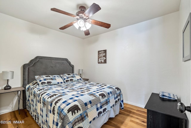 bedroom with a ceiling fan, baseboards, and wood finished floors