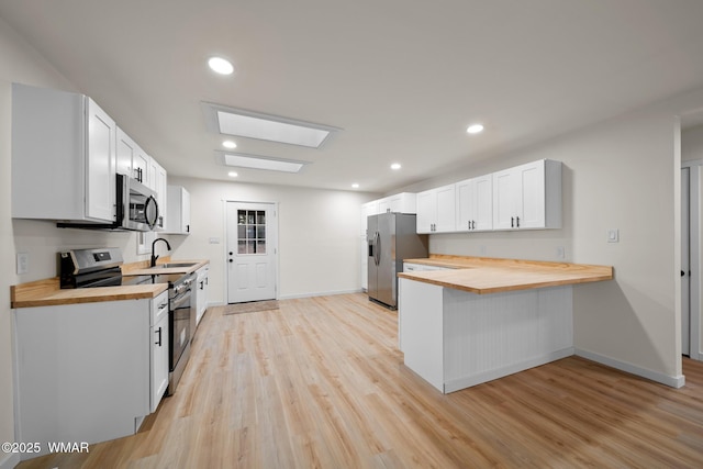 1259 S Penrod Dr, Pinetop, AZ 85935 - kitchen with butcher block counters, appliances with stainless steel finishes, light wood-style flooring, a skylight, and recessed lighting