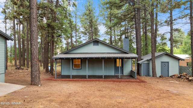 1259 S Penrod Dr, Pinetop, AZ 85935 - view of front of house featuring a shed, a chimney, a porch, and a metal roof