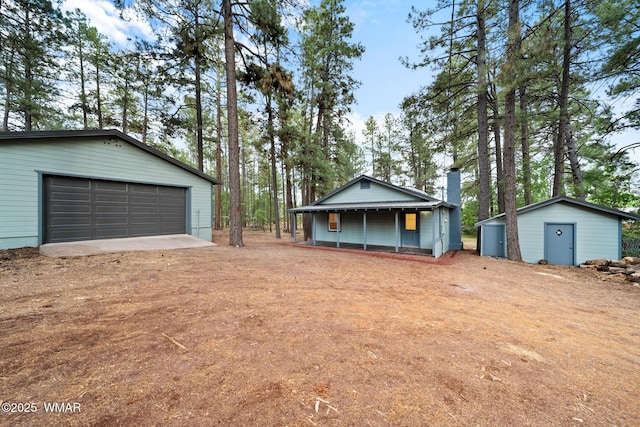 1259 S Penrod Dr, Pinetop, AZ 85935 - view of front of house featuring an outbuilding, a chimney, and a garage