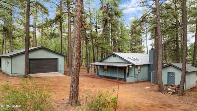 1259 S Penrod Dr, Pinetop, AZ 85935 - view of front facade with an outdoor structure, a detached garage, a chimney, and covered porch
