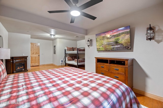 3530 Soaring Eagle Way, Pinetop, AZ 85935 - bedroom with wood finished floors, baseboards, and a glass covered fireplace