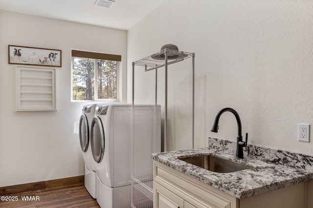 laundry area with separate washer and dryer, dark wood-style floors, cabinet space, and baseboards