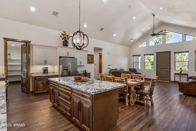 kitchen with stainless steel fridge with ice dispenser, open floor plan, dark wood-type flooring, high vaulted ceiling, and white cabinetry