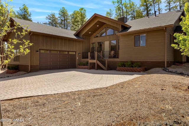 rustic home with an attached garage, decorative driveway, a chimney, crawl space, and a shingled roof