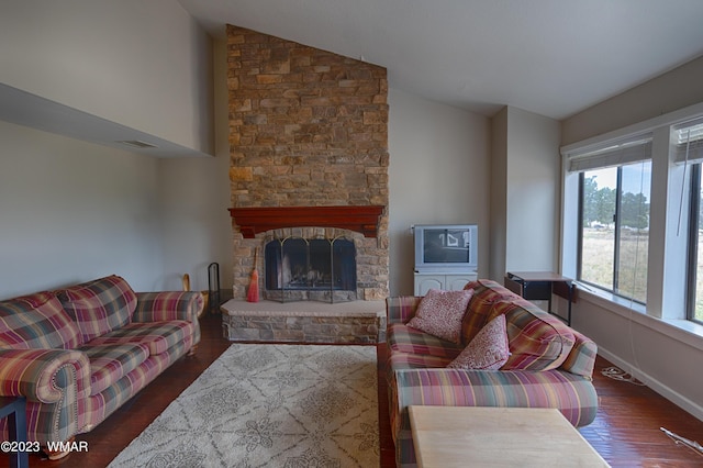 living room featuring wood finished floors, visible vents, baseboards, lofted ceiling, and a fireplace