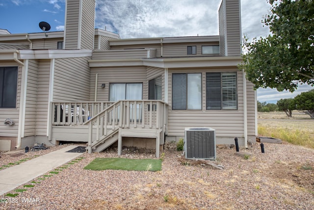 exterior space featuring central AC unit and a chimney