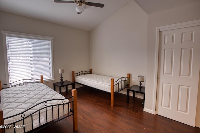 bedroom with a ceiling fan, lofted ceiling, wood finished floors, and baseboards