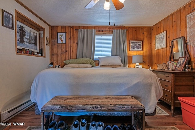 1888 Meadow St, Lakeside, AZ 85929 - bedroom with a baseboard radiator, wood finished floors, wood walls, and a textured ceiling