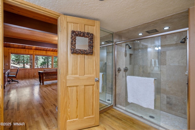 38684 State Route 373, Greer, AZ 85927 - full bathroom with wood finished floors, a stall shower, a textured ceiling, and wood walls