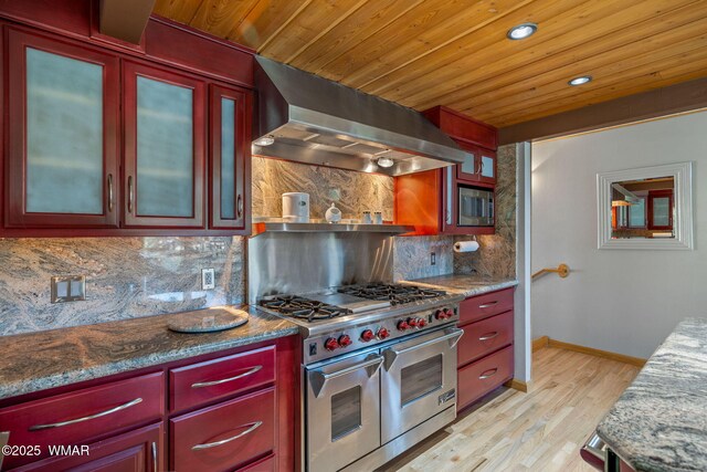 38684 State Route 373, Greer, AZ 85927 - kitchen featuring stainless steel appliances, wall chimney exhaust hood, dark brown cabinets, decorative backsplash, and light wood-style flooring