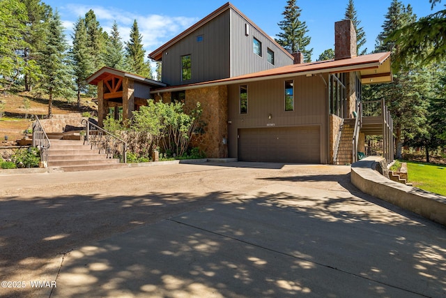 38684 State Route 373, Greer, AZ 85927 - view of front of house with stairway, driveway, an attached garage, and a chimney