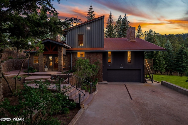 38684 State Route 373, Greer, AZ 85927 - view of front of house with stairs, a garage, concrete driveway, stone siding, and a chimney