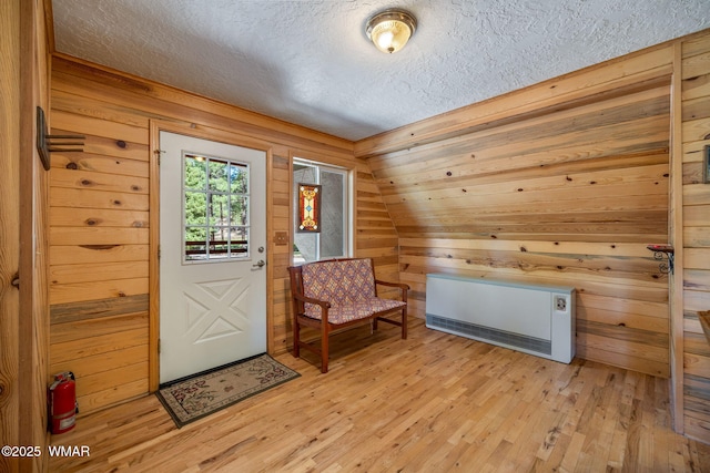38684 State Route 373, Greer, AZ 85927 - foyer entrance featuring a textured ceiling, wooden walls, light wood-style floors, and heating unit