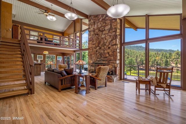 38684 State Route 373, Greer, AZ 85927 - living room with wood finished floors, high vaulted ceiling, stairway, a stone fireplace, and a wood ceiling with exposed beams