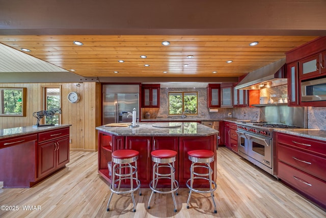 38684 State Route 373, Greer, AZ 85927 - kitchen with dark brown cabinets, built in appliances, light wood-style flooring, wood ceiling, and a kitchen island with sink