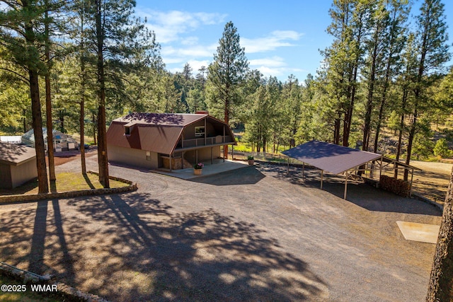 38684 State Route 373, Greer, AZ 85927 - back of house featuring driveway, a gambrel roof, a chimney, and a forest view