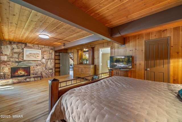 38684 State Route 373, Greer, AZ 85927 - bedroom featuring a wood ceiling with exposed beams, wood walls, a fireplace, and wood finished floors