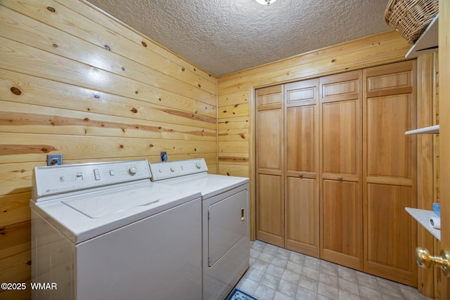 38684 State Route 373, Greer, AZ 85927 - laundry room featuring washing machine and dryer, wooden walls, a textured ceiling, and cabinet space